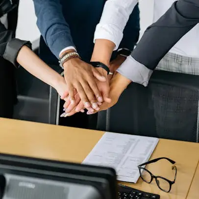 Team members joining hands in a show of unity